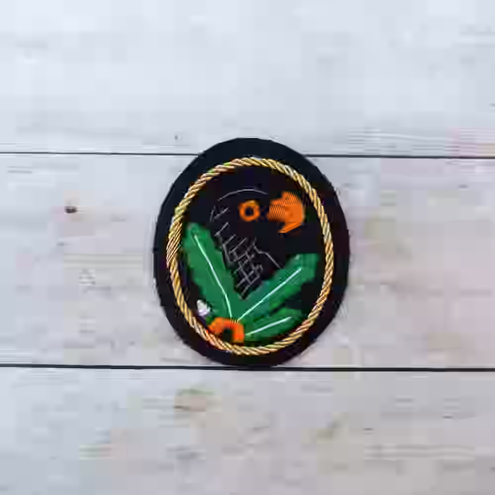 First Class Sniper Badge with Gold Trim First Class Sniper Badge with Gold Trim – Premium Replica, made of Gold cord trim with embroidered eagle on fabric base