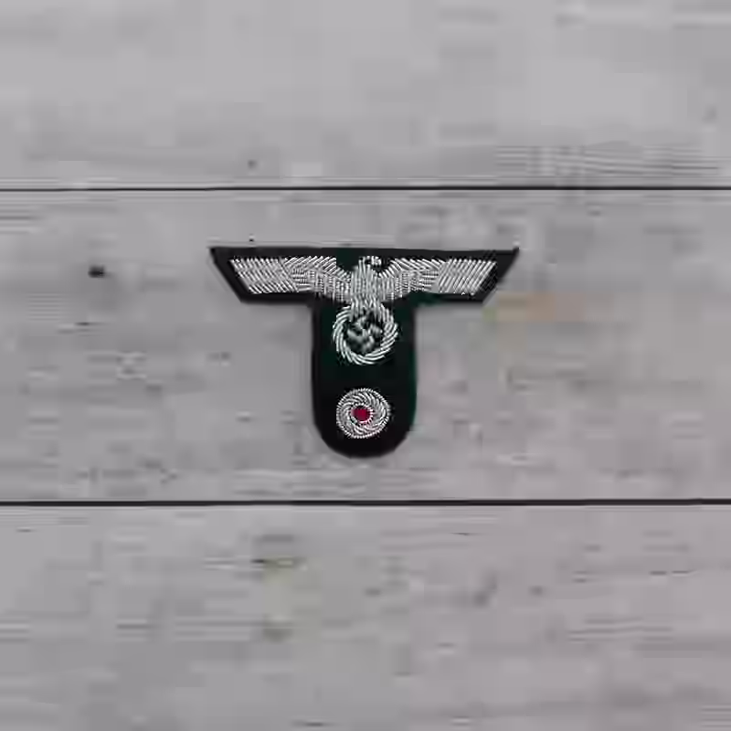 Gebirgsjäger Hand Embroidered Officer's Cap Insignia Gebirgsjäger Hand Embroidered Officer's Cap Insignia – Premium Replica, made of Hand-embroidered silver thread eagle on dark green wool background