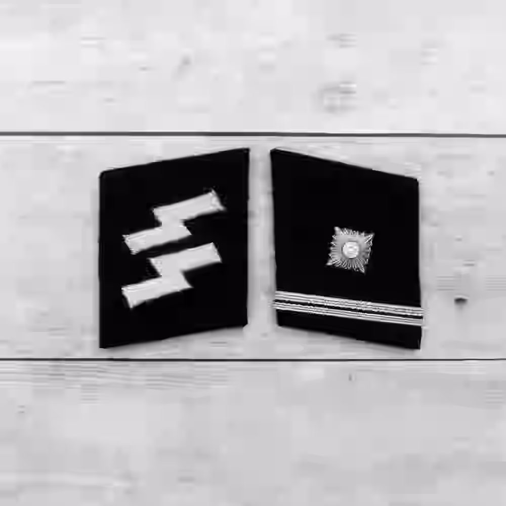 SS Scharführer Collar Tabs SS Scharführer Collar Tabs – Premium Replica, made of One metallic silver star and one line of aluminum litzen on black wool background