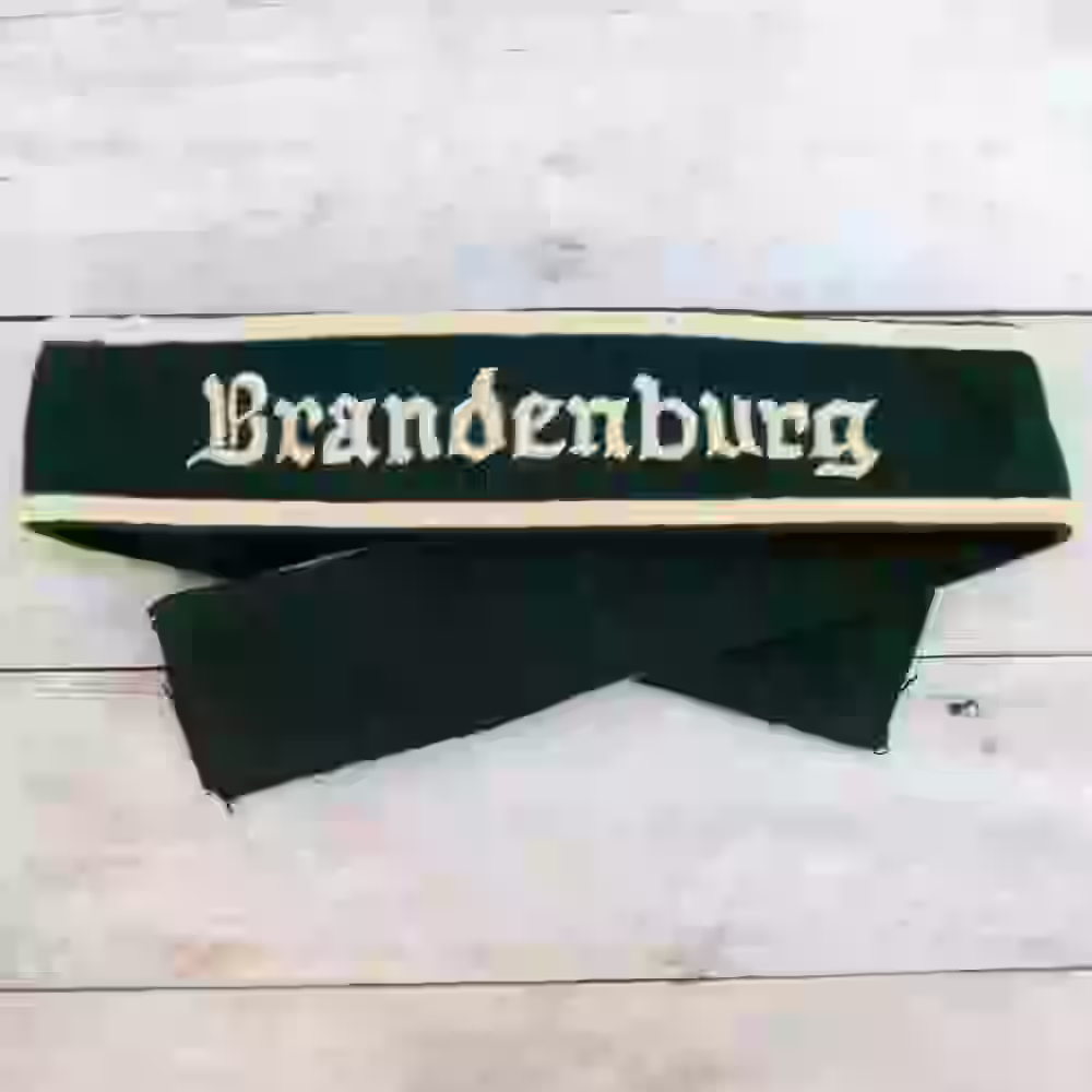 Brandenburg Division Hand-Embroidered Cuff Title Brandenburg Division Hand-Embroidered Cuff Title – Premium Replica, made of Hand-embroidered beige thread on dark green wool background