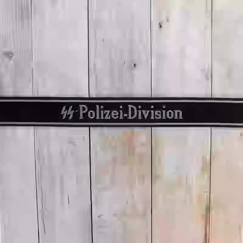 SS Polizei Division EM Cuff Title SS Polizei Division EM Cuff Title – Premium Replica, made of Black silk with hand-embroidered grey thread