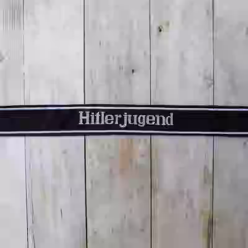 Hitlerjugend EM Cuff Title Hitlerjugend EM Cuff Title – Premium Replica, made of Black woven silk with hand-embroidered grey thread