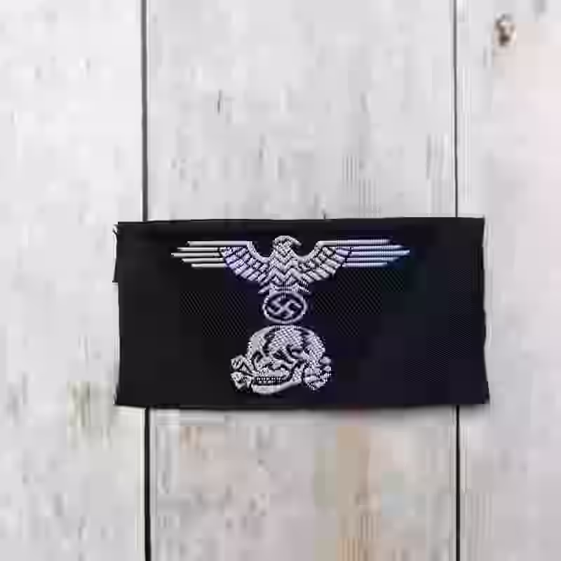 Panzer-SS Enlisted Men's Woven Trapezoid Cap Insignia Panzer-SS Enlisted Men's Woven Trapezoid Cap Insignia – Premium Replica, made of Be-Vo woven white thread on black cotton background