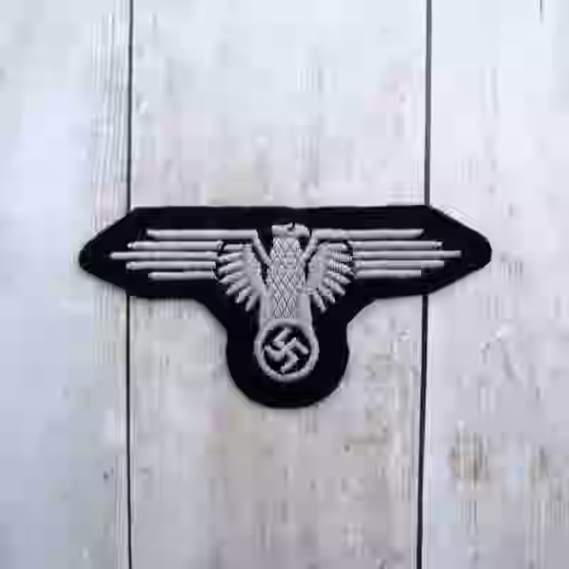 Waffen SS Enlisted Men’s Cloth Embroidered Arm Eagle Waffen SS Enlisted Men’s Cloth Embroidered Arm Eagle – Premium Replica, made of Black fabric with hand-embroidered white thread