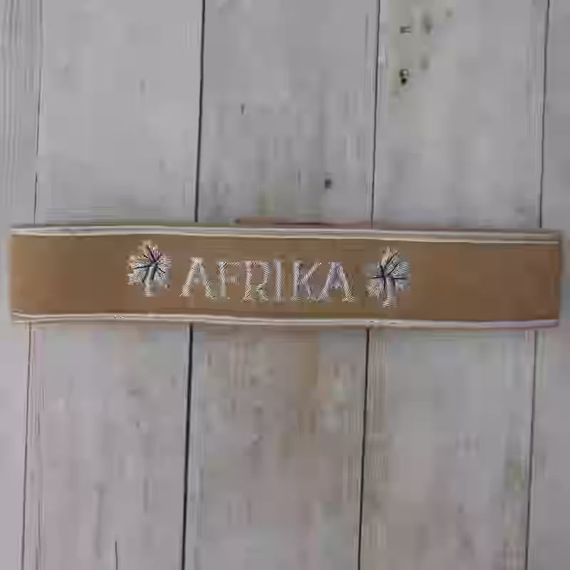 Afrika Korps Military Award Cuff Title Afrika Korps Military Award Cuff Title – Premium Replica, made of Tan wool with silver lettering