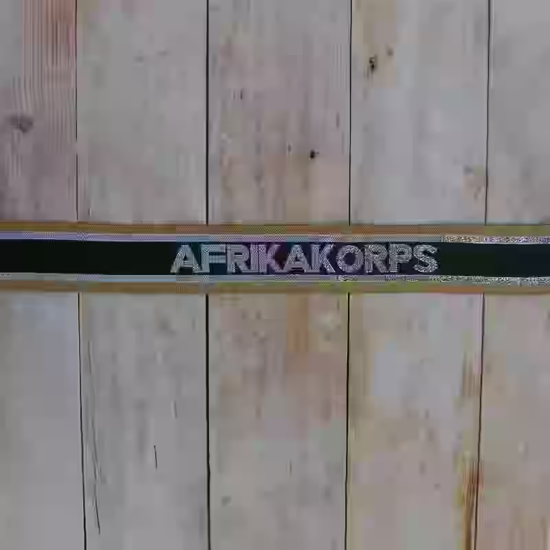 DAK Afrika Korps Wehrmacht Enlisted Men's Cuff Title DAK Afrika Korps Wehrmacht Enlisted Men's Cuff Title – Premium Replica, made of Machine-embroidered silver cotton thread on tan and green silk background